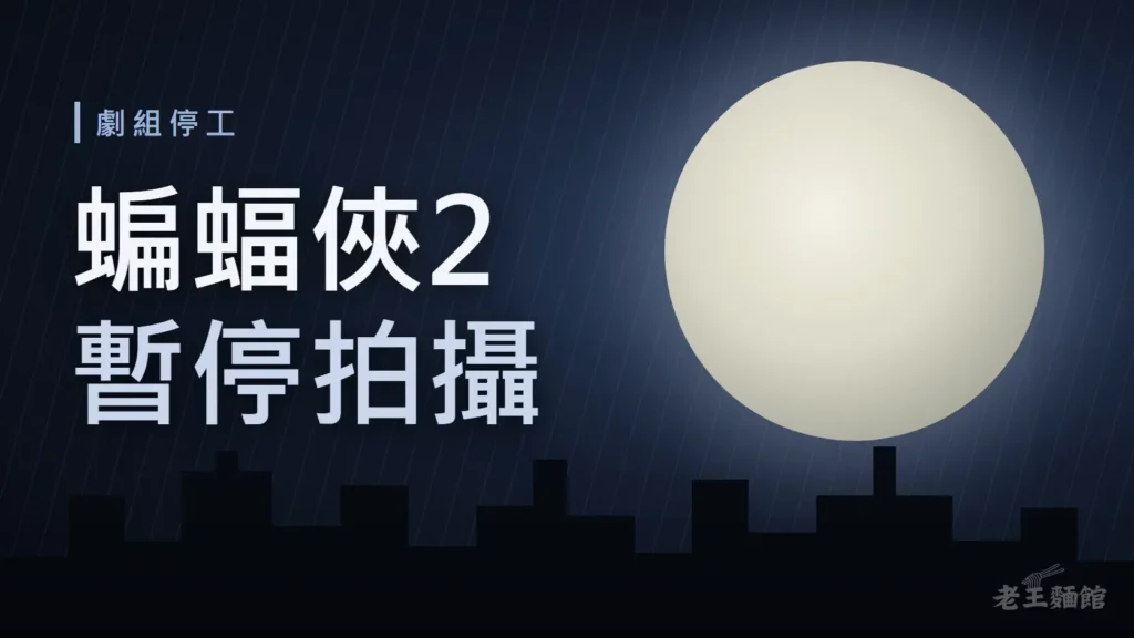 深藍夜色封面，左側大字寫著蝙蝠俠2、暫停拍攝，上方小標劇組停工；右側是一輪滿月，下方是黑色城市天際線剪影與斜斜的雨絲。